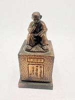 Front view of bronze statue showing poet seated on pedestal with inscription