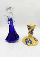 Front view of cobalt blue glass angel figurine and yellow ceramic candlestick