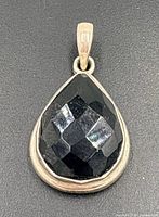 Front view of pendant showing faceted onyx and silver bezel