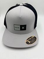 Grey front panel with black mesh Hurley 110 snapback cap showing logo patch and sticker