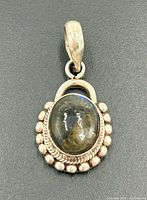 Front view of oval labradorite sterling silver pendant with decorative border