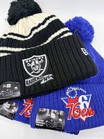 Front view of Raiders beanie and two 76ers beanies showing logos and tags