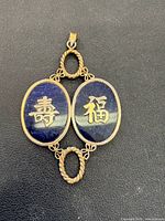 front view showing two lapis lazuli ovals with gold-tone Chinese characters in gold-colored setting