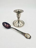 Candlestick and spoon side by side, front view