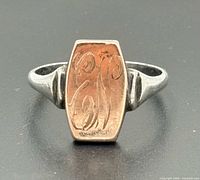 Front view of signet ring showing two-tone shield and monogram