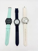 Front view of three wristwatches with different strap colours