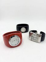 Three watches: red resin bangle, black quilted bangle, black cuff with rectangular case