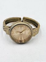 Front view of gold-tone cuff wristwatch