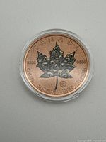 Obverse of copper round showing maple leaf with skull motif and inscriptions