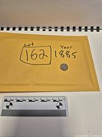 Entire lot with envelope, scale and coin visible