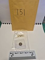 Full lot showing coin inside clear sleeve