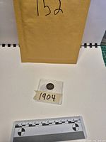 Full view of coin in sleeve with scale reference