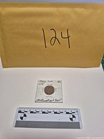 Envelope and coin in holder with measurement scale