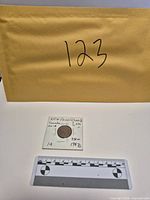 Full view of coin in holder with scale reference