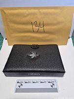 Closed black presentation case with maple leaf crest