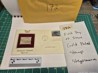 Front view of first-day cover showing gold-plated stamp and real 25-cent stamp
