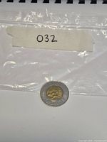 Full view of single 2000 Canadian $2 coin in plastic bag labeled 032