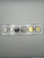 Front view showing reverse designs of six 2023 coins in holder