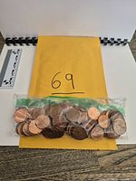 Sealed plastic bag of Canadian pennies on envelope