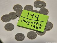 Group of coins with note indicating lot 194 and magnetic 1968