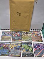 All eight sleeved Pokémon cards arranged in two rows