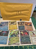 All eight sleeved Pokémon cards arranged on white background