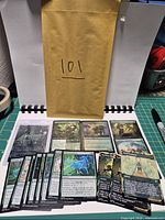 Entire group of loose cards fanned out with one sleeved card and envelope marked 101.