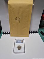Context photo of encapsulated coin with lot number sheet