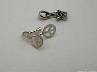 front view of peace-sign earrings and star pendant