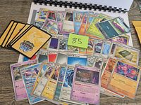 Overview of all loose Pokémon cards and code cards spread on table