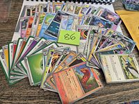 Wide view of all fanned Pokémon cards, trainer, energy and code cards on table