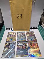 All six sleeved cards displayed on binder page beside envelope