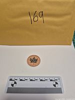 Round with scale and envelope showing size reference