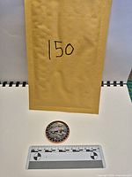 Envelope, copper round front view with scale