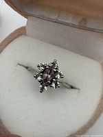 Ring in open box showing cluster setting and stones