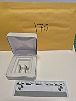Earrings in presentation box with scale ruler