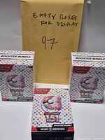 Front view of three empty Pokémon 151 Booster Bundle boxes and envelope noting empty boxes
