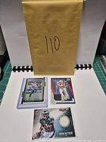 Overview showing all three football memorabilia cards in sleeves; one card in hard plastic holder