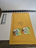 Both enamel pins front view on envelope