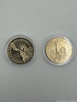 Both coins reverse sides showing Statue of Liberty, in plastic holders