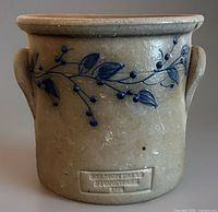 Front view showing blueberry vine decoration and maker’s stamp