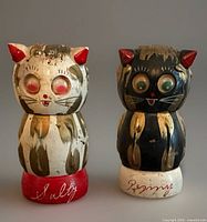 Front view of both wood cat shakers showing faces, paint, labels