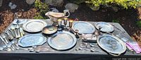 Full lot overview of platters, flatware, goblets, candlesticks on table