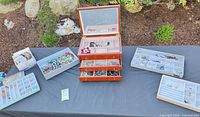 All lot contents displayed on table including open wood jewelry box, trays of jewelry, box of watches