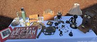 Overall lot on table showing telephone, sign, crate, insulators, thermos, lantern, brass items