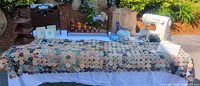 Overhead view of entire lot on table showing quilt layout, sewing machine, wood racks, dolls, yarn