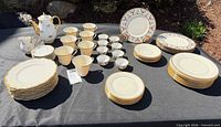 Entire lot laid out including Lenox plates, cups, saucers, teapot, and Italian plates