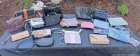 Group shot of all 15 bags, clutches and wallets on table