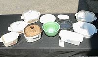 Entire assortment of casseroles, bowls, pie plate and lids displayed on table