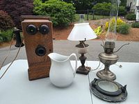 Group shot of telephone, pitcher, two oil lamps, porthole